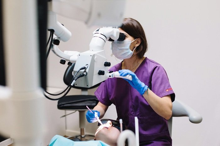 An orthodontist using advanced dental equipment to examine a patient
