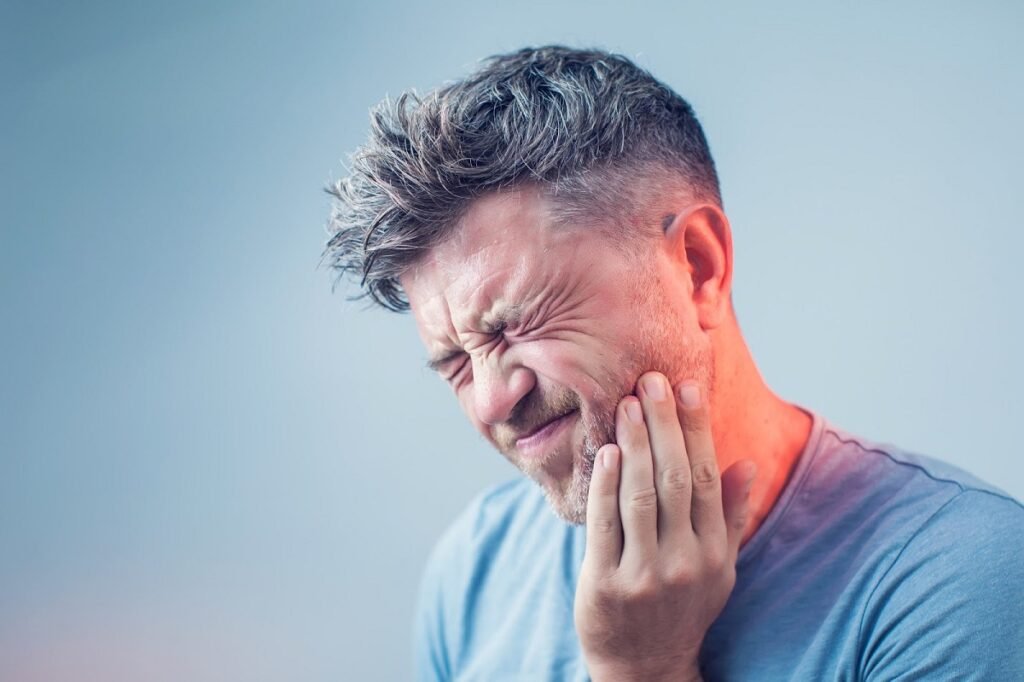 A clinched face of a man struggling with any kind of dental emergency like toothache or broken tooth