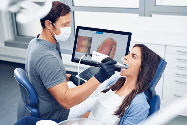 A dentist taking digital dental impression of a patient with the help of an intraoral digital scanner