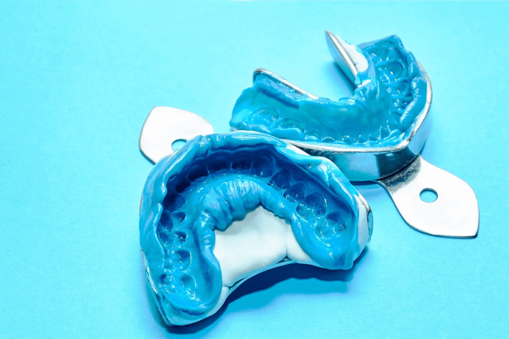 Dental impressions of a patient's oral structure using blue material on dental trays