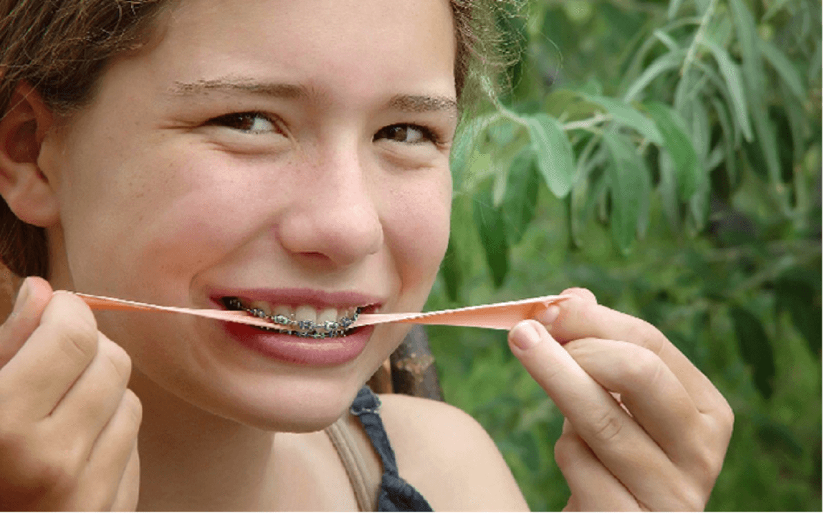Image of a girl trying to eat chewing gum and spreading it with her hands