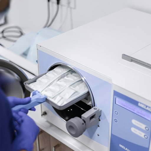 Medical sterilizer in operation with gloved hands