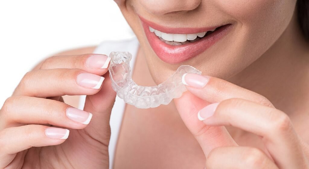 Smiling woman holding a clear dental splint