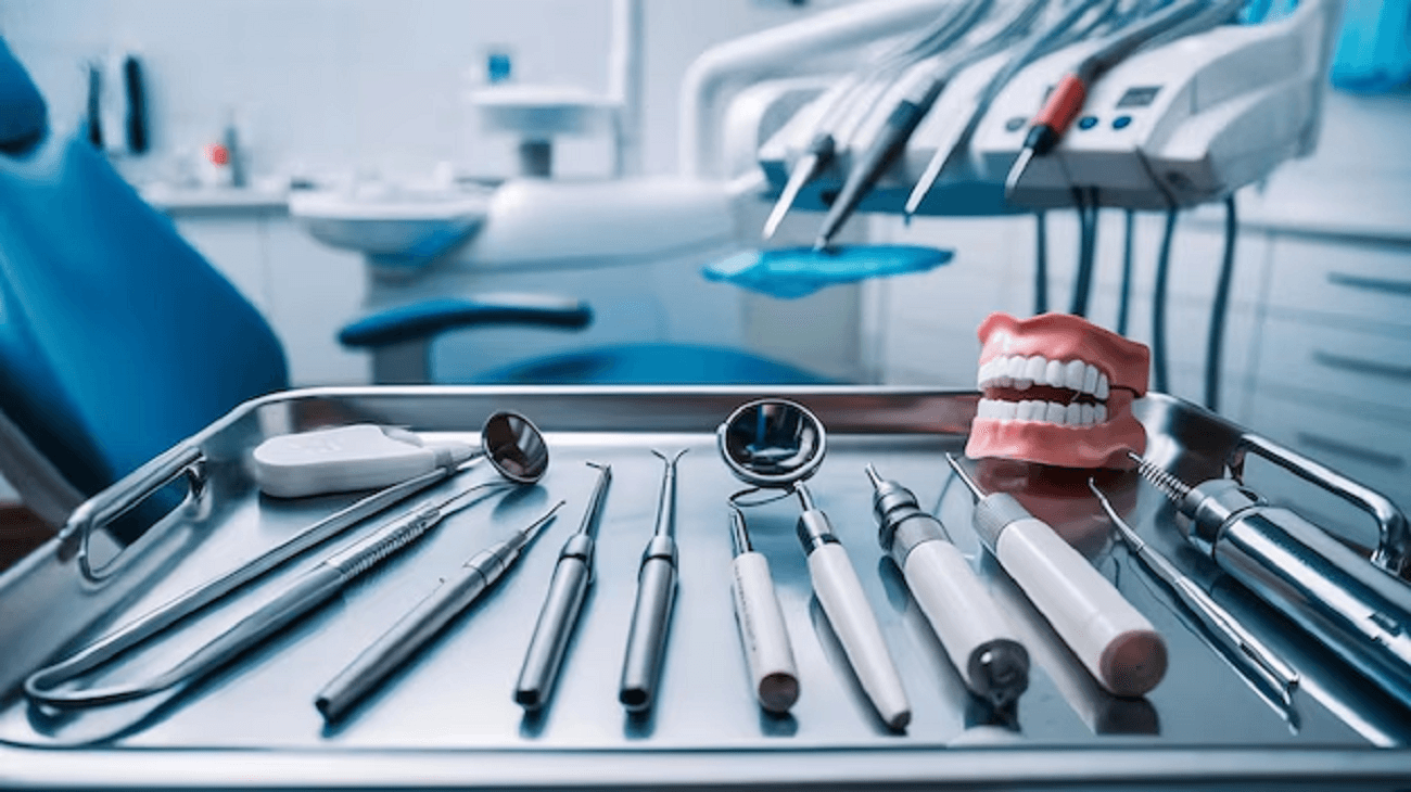 The image shows different types of dental tools and equipment with a set of artificial dentures