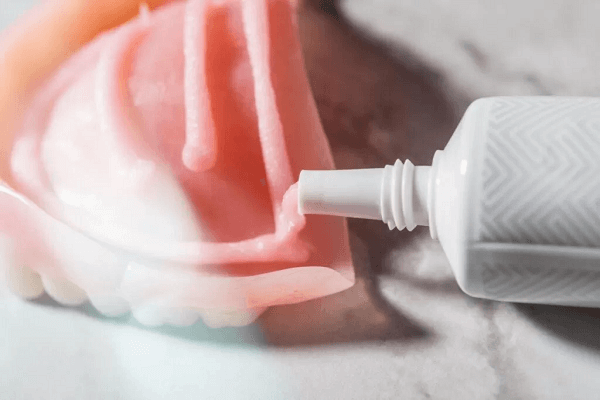 Visual representation of preparing adhesive dentures for application