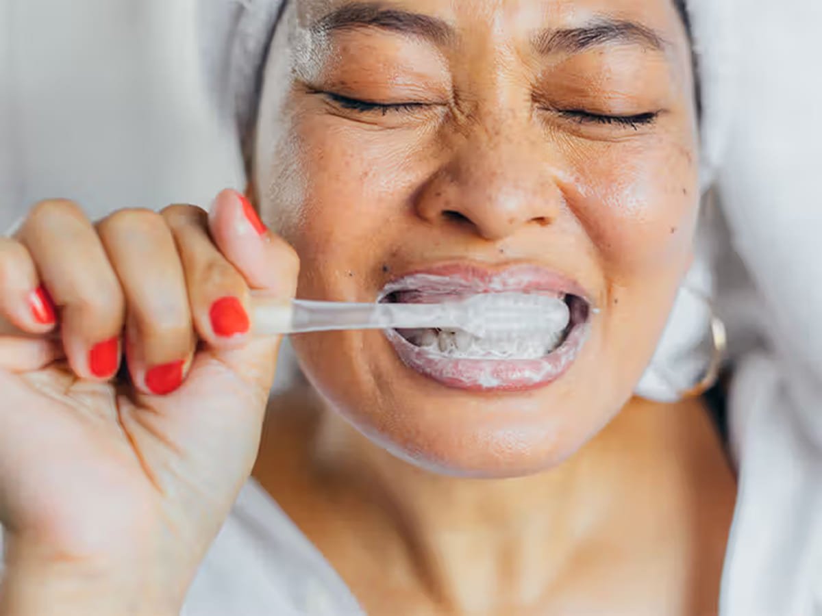 Woman brushing with sodium fluoride dental paste