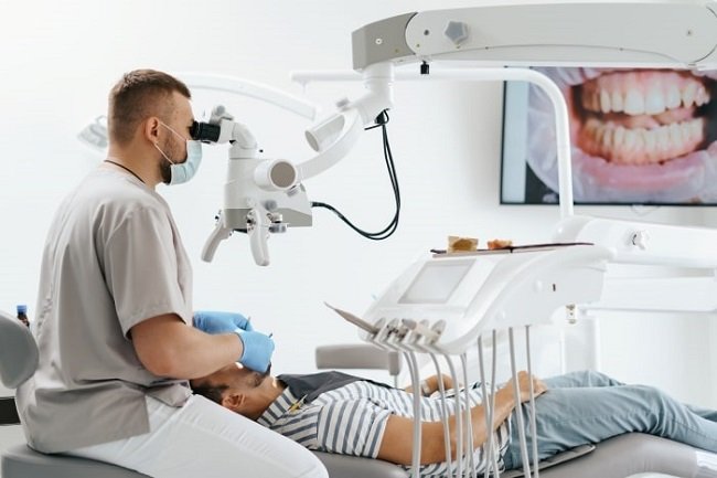 dentist inspecting the patient’s teeth