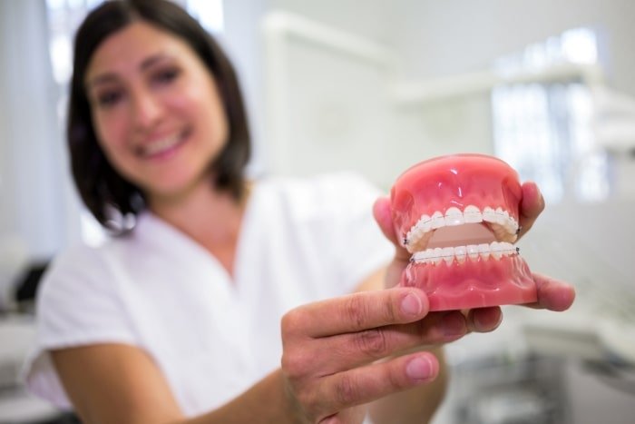 female dentist holding a set of dentures