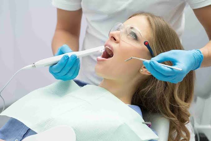 using an intraoral camera to check the patient’s oral cavity